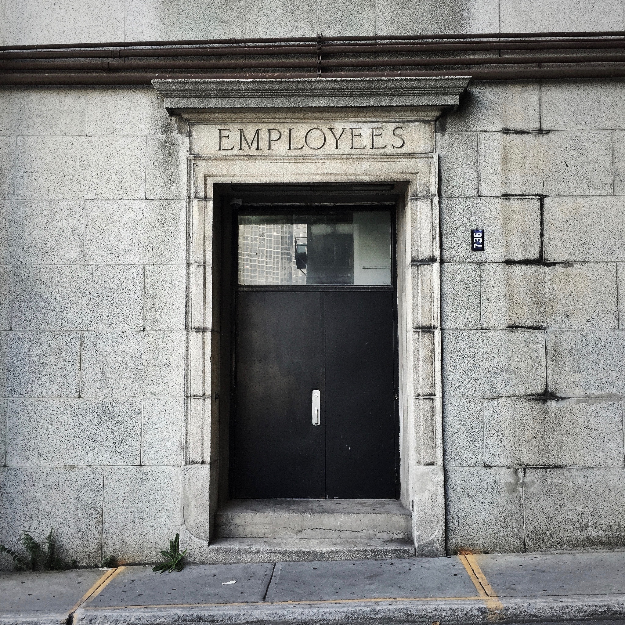 Door in brink building labeled Employees