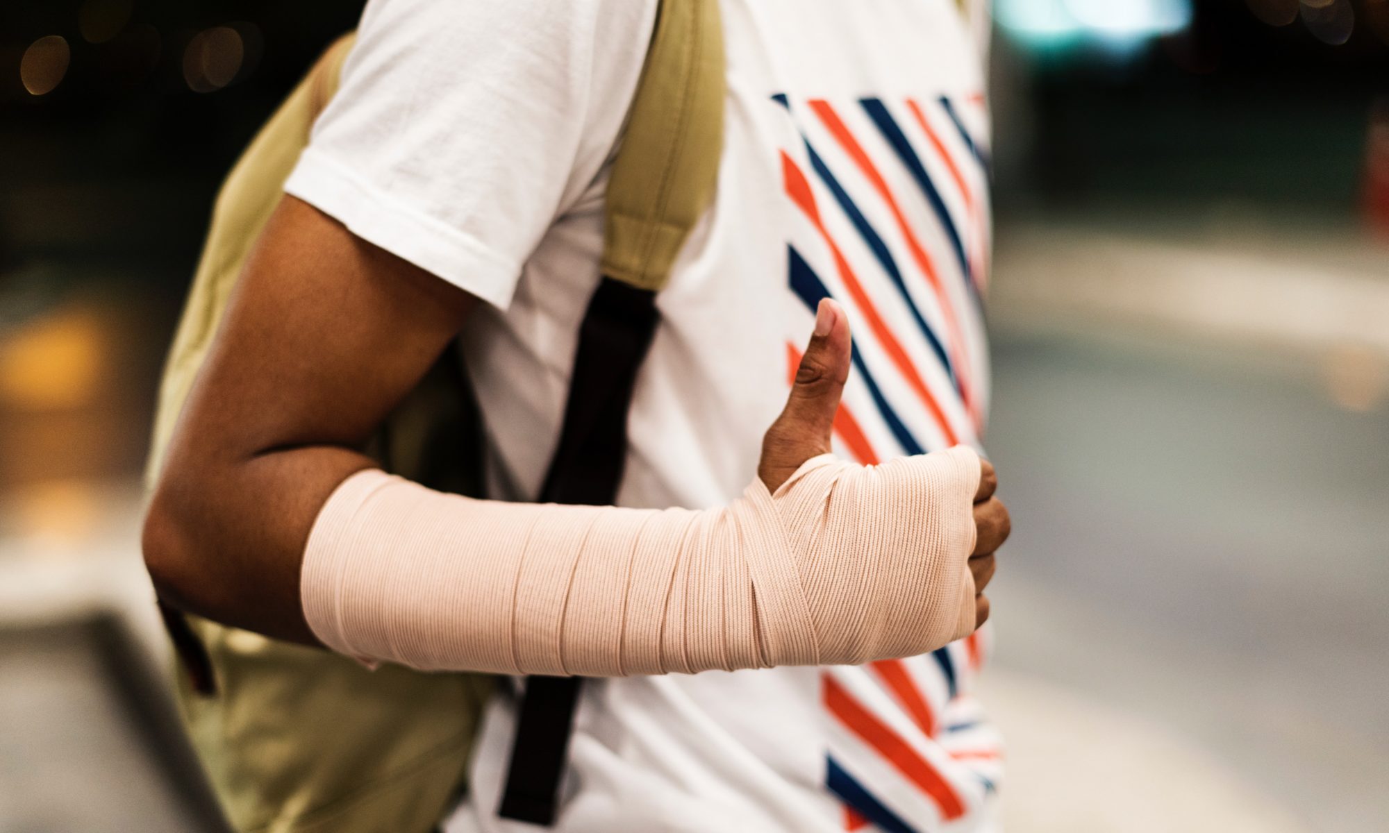 man with hand bandage wearing backpack standing